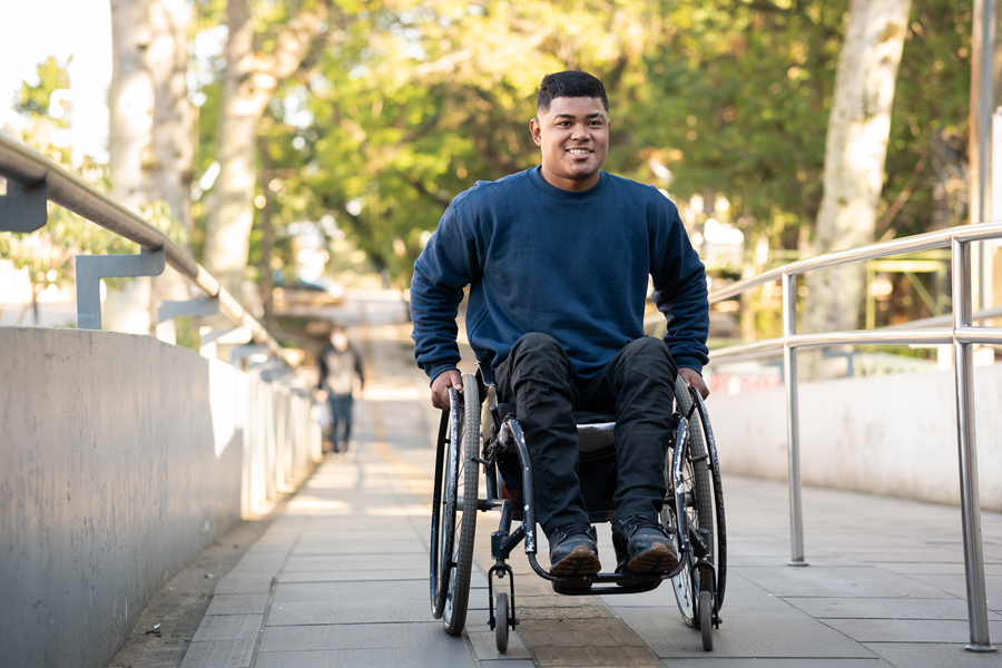 A man in a wheelchair goes along the access ramp.